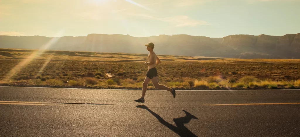 Man running on an open road in the day 